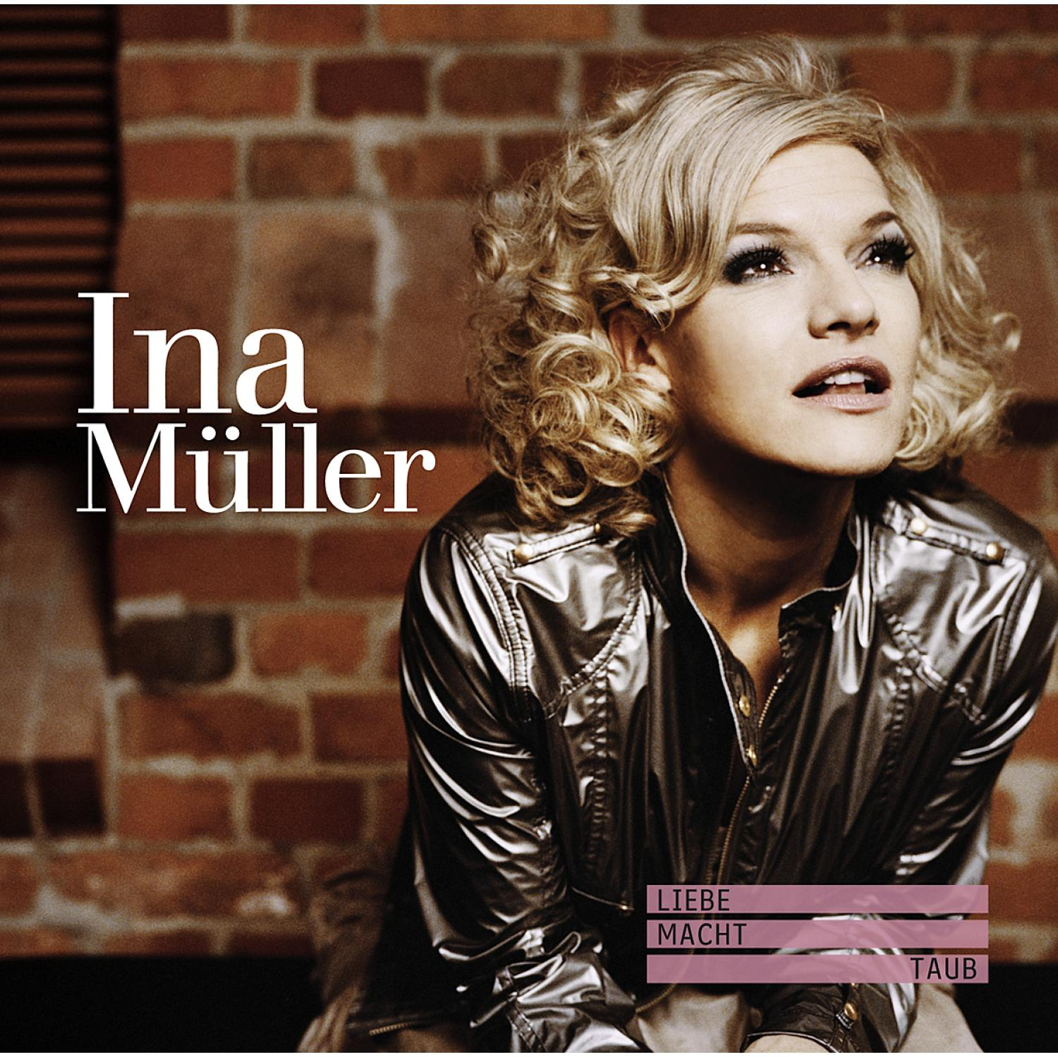 Ina Müller Albumcover. Blonde Frau in silberner Jacke, Backsteinmauer im Hintergrund.